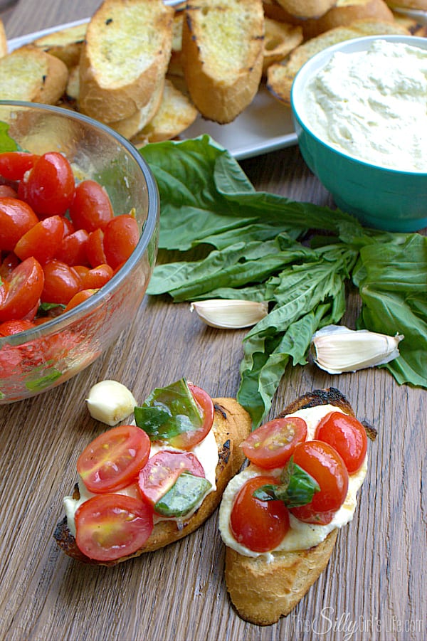Bruschetta with Whipped Feta and Grilled Crostini, grilled baguette smeared with creamy whipped feta spread and topped with fresh grape tomatoes marinated in a sweet and tangy basil vinaigrette. 